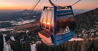 Arizona Snowbowl gondola above snowy pines at sunset
