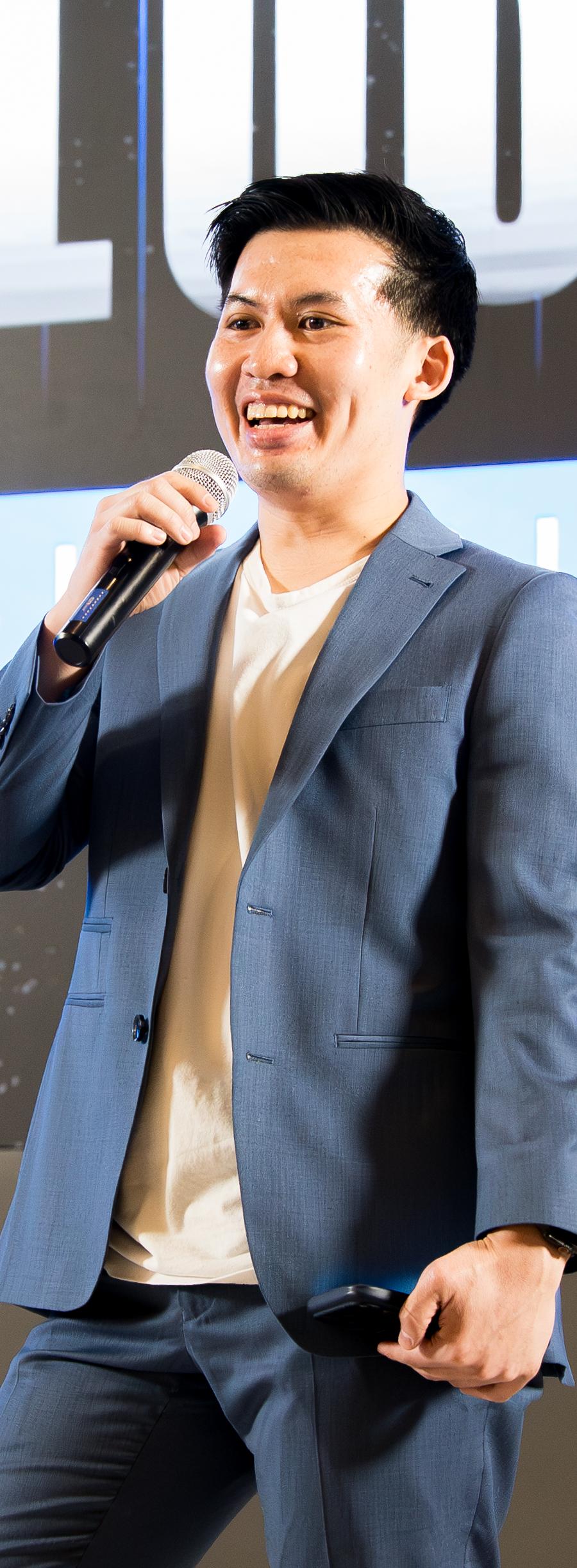 Thomas Ma on stage with a microphone