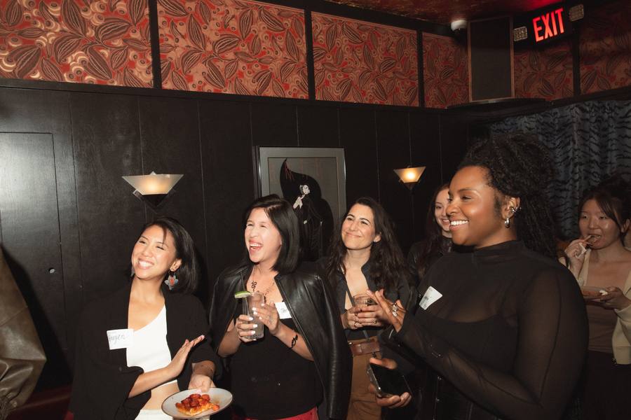 Guests laughing over drinks at the Mercury room